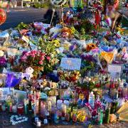 A memorial in Las Vegas, with flowers, balloons, photos and candles, 纪念大规模枪击案的受害者.