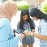 PhD student Kawther Rouabhi helping two high school students troubleshoot their camera.